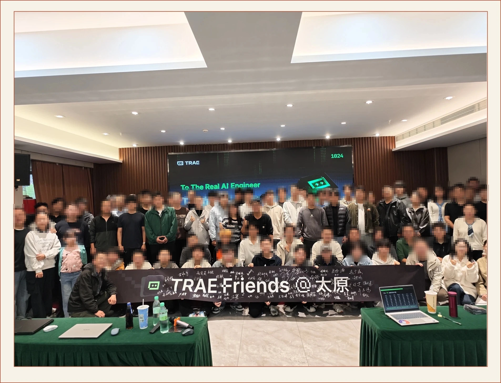 14:40,1024 合影:横幅上签满了名字,屏幕写着“To The Real AI Engineer”。
